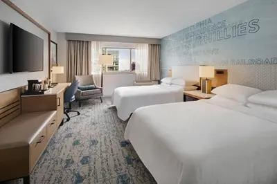 a hotel room with two beds and a flat screen tv at Sheraton Philadelphia Downtown in Philadelphia