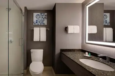 a bathroom with a toilet and a sink and a mirror at Sheraton Philadelphia Downtown in Philadelphia