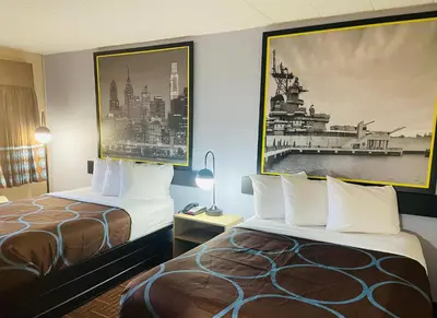 a hotel room with two beds and a picture on the wall at Super 8 by Wyndham Gloucester in Gloucester City