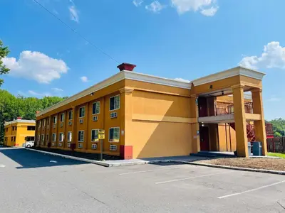 a large yellow building with a parking lot at Super 8 by Wyndham Gloucester in Gloucester City