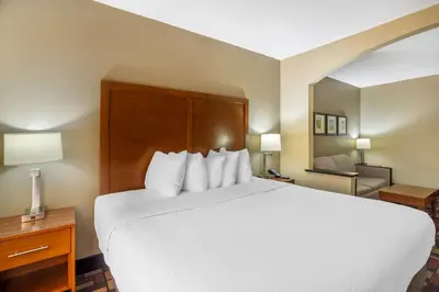 a hotel room with a large white bed and a chair at Best Western Harrisburg I-81 Grantville Hershey in Grantville