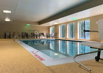 a swimming pool in a room with tables and chairs at Best Western Harrisburg I-81 Grantville Hershey in Grantville