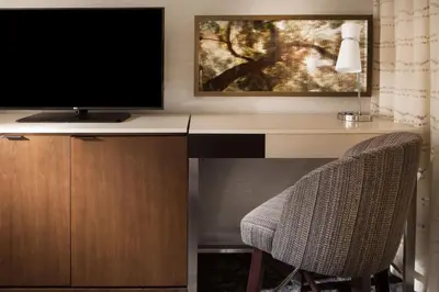 a desk with a television and two chairs at The Westin Princeton at Forrestal Village in Princeton