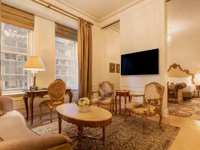 a living room with a couch and a tv at The Plaza in New York
