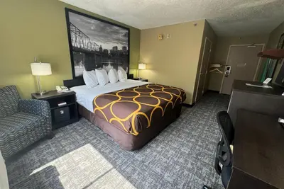 a hotel room with a bed and a chair at Super 8 by Wyndham New Cumberland in New Cumberland