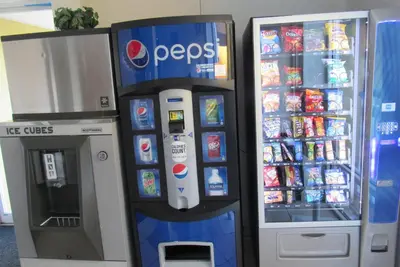 a pepsi drink dispenser next to a soda machine at Super 8 by Wyndham New Cumberland in New Cumberland