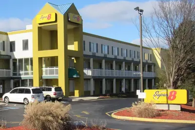 a yellow and white building with cars parked in a parking lot at Super 8 by Wyndham New Cumberland in New Cumberland