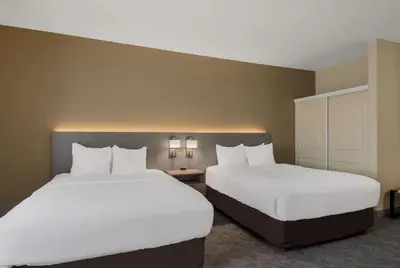two beds in a hotel room with white sheets at Comfort Inn & Suites Barnesville - Frackville in Barnesville