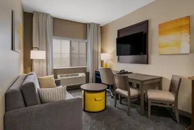 a living room with a couch and a table with a desk at Comfort Inn & Suites Barnesville - Frackville in Barnesville
