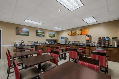 a dining room with tables and chairs and a counter at Comfort Inn & Suites Barnesville - Frackville in Barnesville