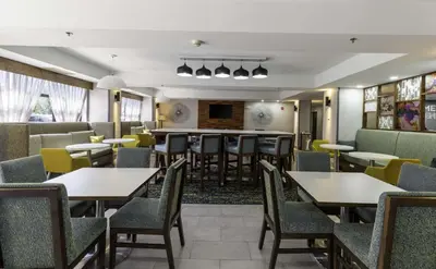a restaurant with tables and chairs and a bar at Hampton Inn East Windsor in East Windsor