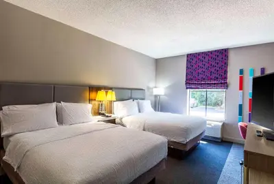 a hotel room with two beds and a flat screen tv at Hampton Inn East Windsor in East Windsor