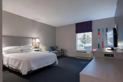 a hotel room with a bed and a flat screen tv at Hampton Inn East Windsor in East Windsor