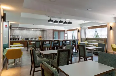 a restaurant with tables and chairs and a bar at Hampton Inn East Windsor in East Windsor