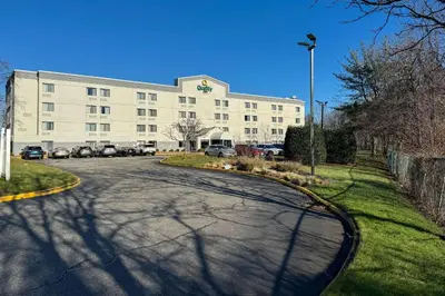 a large white building with cars parked in front of it at Quality Inn Spring Valley - Nanuet in Spring Valley