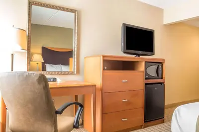 a hotel room with a desk and a tv and a mirror at Quality Inn Spring Valley - Nanuet in Spring Valley