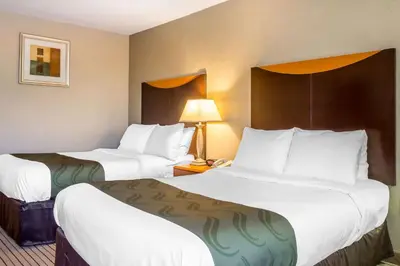 a hotel room with two beds and a lamp at Quality Inn Spring Valley - Nanuet in Spring Valley