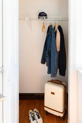 a closet with a suitcase and clothes and shoes at Sosuite at Independence Lofts - Callowhill in Philadelphia