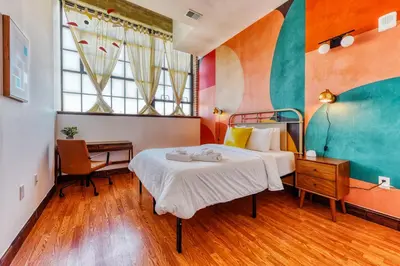 a hotel room with a bed and a desk and window at Sosuite at Independence Lofts - Callowhill in Philadelphia