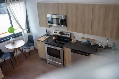 a small kitchen with a stove and a counter top at Continental Congress Loft at Kestrel Hotel in Philadelphia