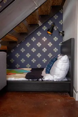 a room with a bed with a cat laying on it at Hive Room Loft at Kestrel Hotel in Philadelphia