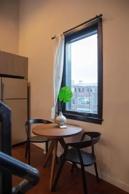 a table and chairs in a room with a window at Hive Room Loft at Kestrel Hotel in Philadelphia