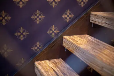 two wooden stairs in a room with a patterned wall at Hive Room Loft at Kestrel Hotel in Philadelphia