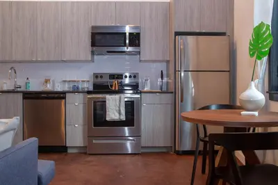 a kitchen with stainless steel appliances and a table at Hive Room Loft at Kestrel Hotel in Philadelphia
