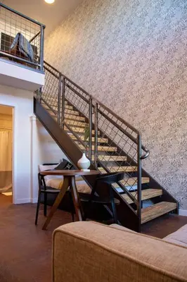 a staircase in a room with a table and chairs at Mayor's Study Loft at Kestrel Hotel in Philadelphia