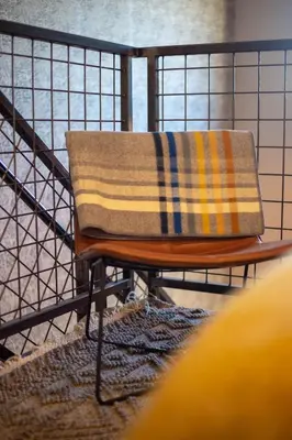 a blanket sitting on a chair on a rug at Mayor's Study Loft at Kestrel Hotel in Philadelphia