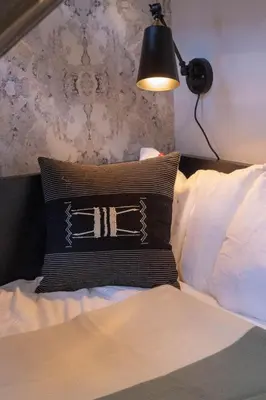 a bedroom with a bed with a pillow and a lamp at Viaduct Loft at Kestrel Hotel in Philadelphia