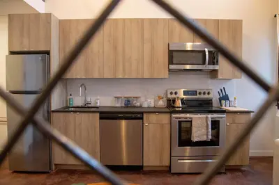 a kitchen with stainless steel appliances and wooden cabinets at Viaduct Loft at Kestrel Hotel in Philadelphia