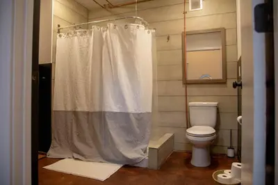 a bathroom with a shower curtain and a toilet at Viaduct Loft at Kestrel Hotel in Philadelphia