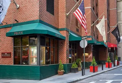 a facade of a brick building with an american flag at Gild Hall, A Thompson Hotel, by Hyatt in New York