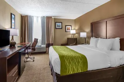 a hotel room with a large bed and a desk at Comfort Inn Edison - New Brunswick in Edison