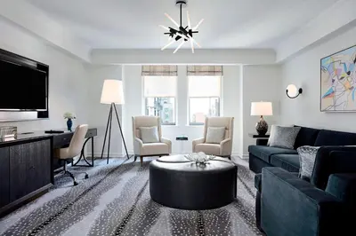 a living room with a blue couch and a tv at JW Marriott Essex House New York in New York
