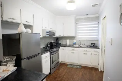 a kitchen with white cabinets and a stainless steel refrigerator at A Modern Apt close to downtown in Lancaster