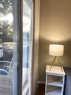 a lamp on a table next to a sliding glass door at A Modern Apt close to downtown in Lancaster
