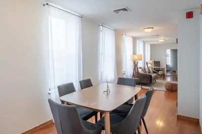 a dining room with a wooden table and chairs at The Stairway Suites - Convention Center in Philadelphia
