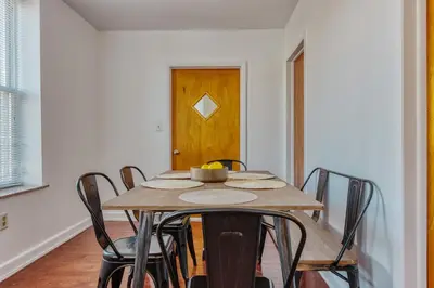 a dining room table with chairs and a wooden door at The Stairway Suites - Convention Center in Philadelphia