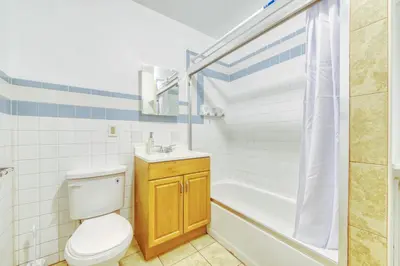 a bathroom with a toilet and a tub and a sink at The Stairway Suites - Convention Center in Philadelphia