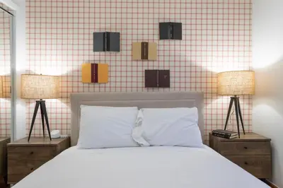 a bedroom with a white bed and two lamps at The Stairway Suites - Convention Center in Philadelphia