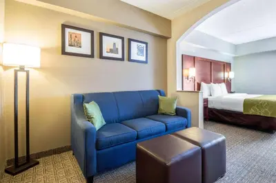 a living room with a blue couch and a bed at Comfort Suites at Woodbridge in Avenel