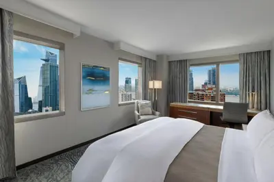 a hotel room with a bed and a desk and windows at The Westin New York at Times Square in New York