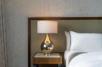 a lamp on a night stand next to a bed at The Westin New York at Times Square in New York