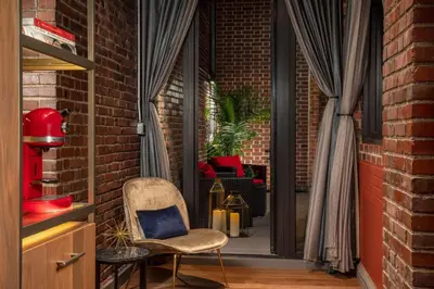 a brick room with a chair and a window at NH Collection New York Madison Avenue in New York