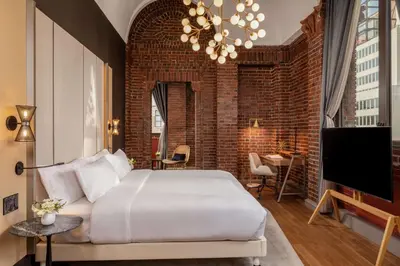 a bedroom with a large bed and a brick wall at NH Collection New York Madison Avenue in New York