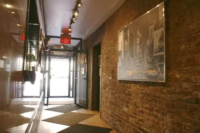 a hallway with a brick wall with a picture on it at Off SoHo Suites Hotel in New York