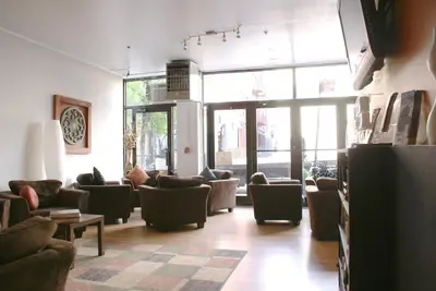 a living room with couches and chairs and windows at Off SoHo Suites Hotel in New York