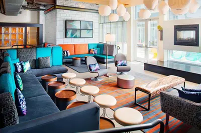 a living room with a couch and chairs and tables at Aloft Philadelphia Airport in Philadelphia